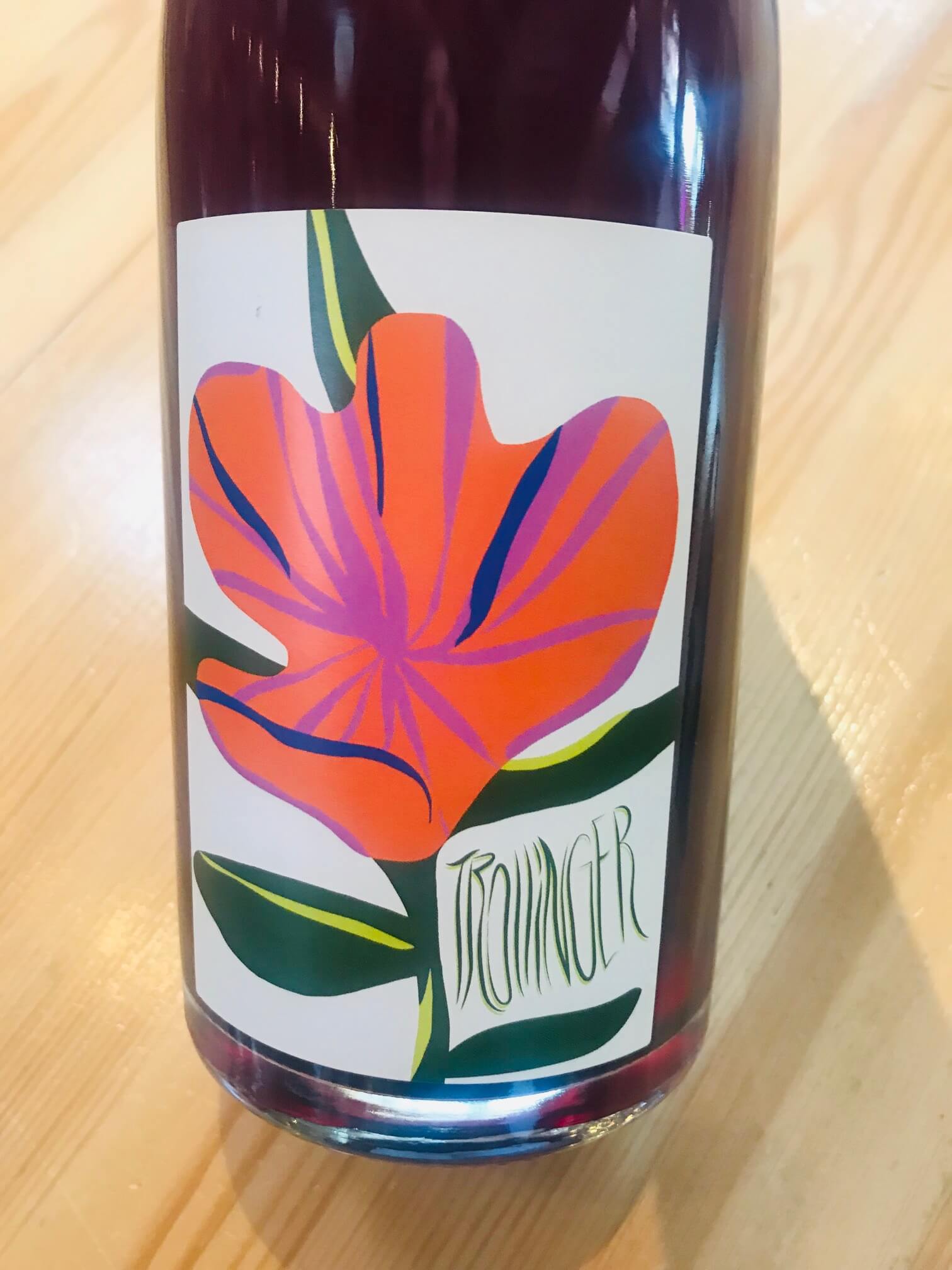 Bottle of Trollinger red wine with a cartoonish artsy red flower on the label